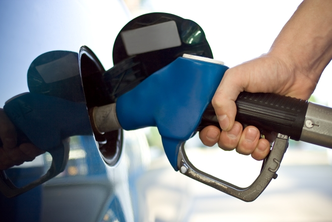 close-up of a mens hand refilling the car with a gas pump
