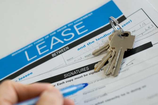 signing a lease with pen and keys