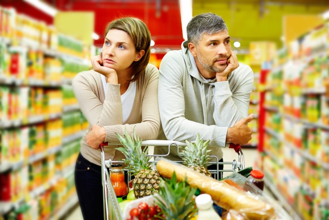 Image of young couple with cart in supermarket