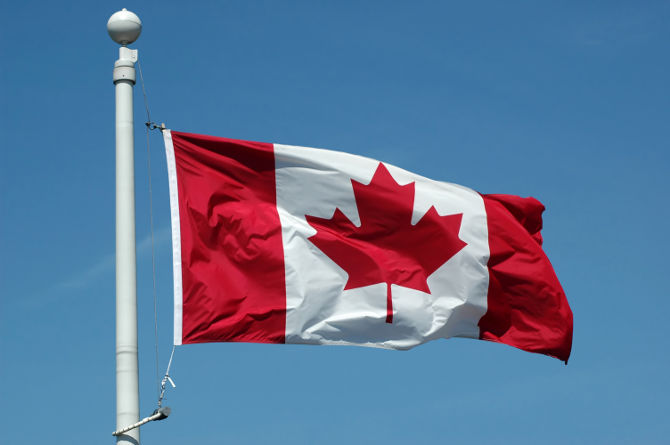 A Canadian flag in blue sky background