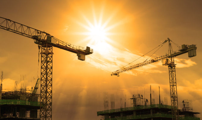 file of crane and building construction and sun set sky