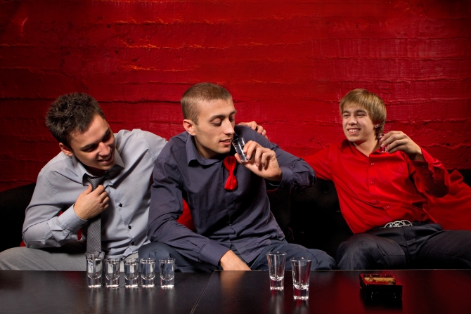 Men drinking shots in night club