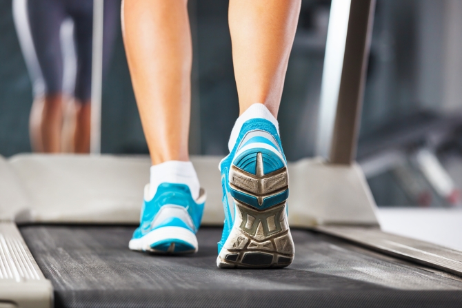 Woman running on treadmill in gym closeup