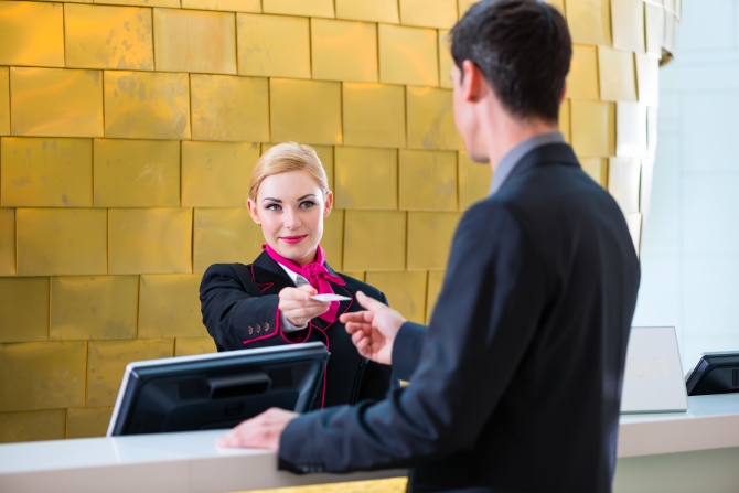 Man in Hotel check in at reception or front office being given key card