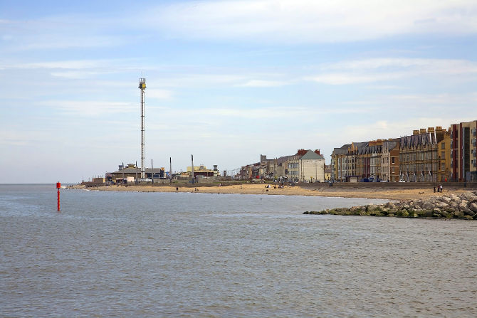 River Clwyd meets Irish sea at Rhyl harbour in north Wales, UK. With disused tourist attraction skytower in the background.